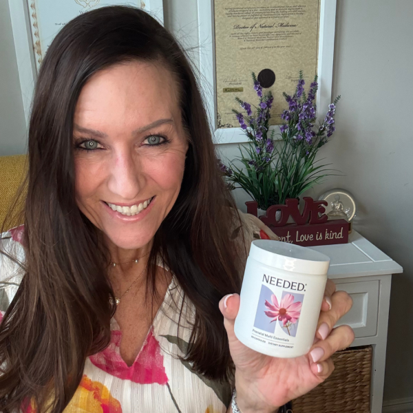 Dr. Kela Smith holding Needed Prenatal Multi supplement in her office